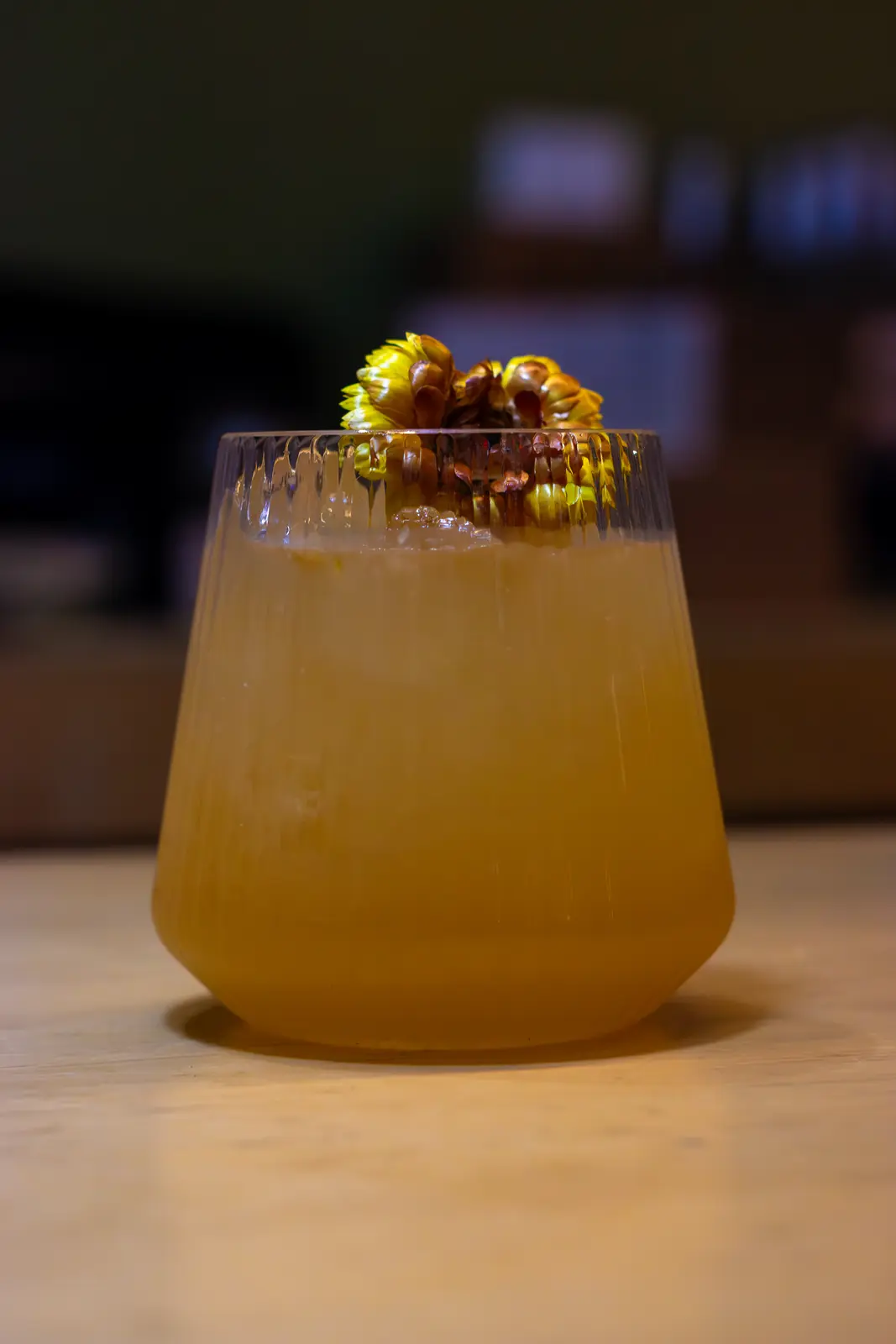 A golden signature cocktail with a sculptural garnish